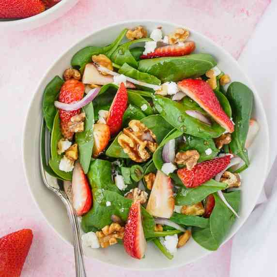 Top view of a plate of strawberry spinach salad.