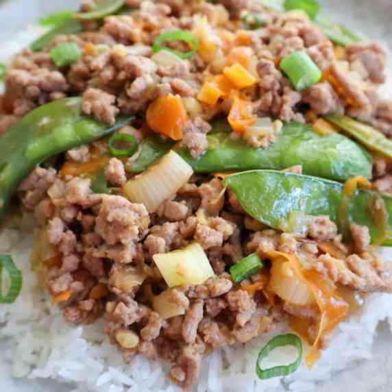 ground turkey with snow peas ground onions on a bed of rice