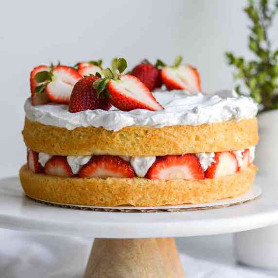 A vegan strawberry shortcake cake on a cake stand 