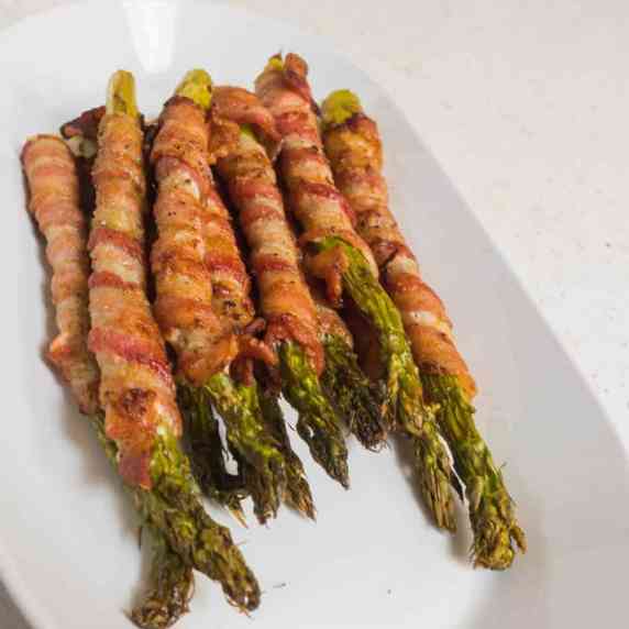 Bacon wrapped asparagus piled on plate