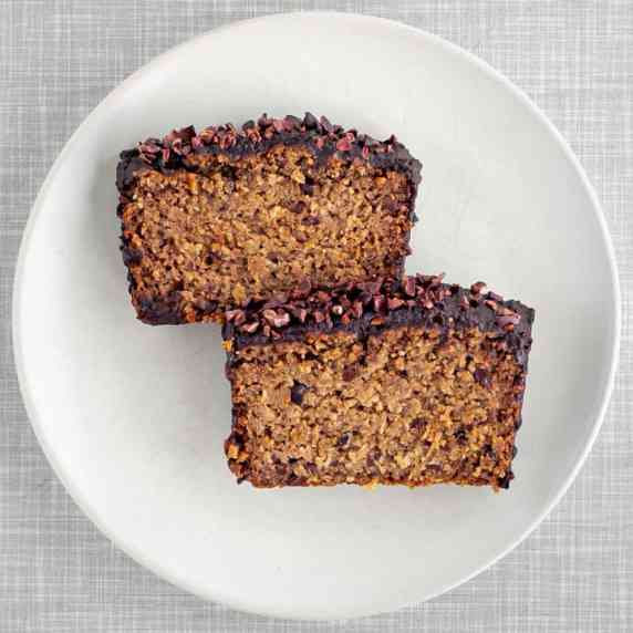 Two slices of a vegan baked oats breakfast cake with chocolate glaze