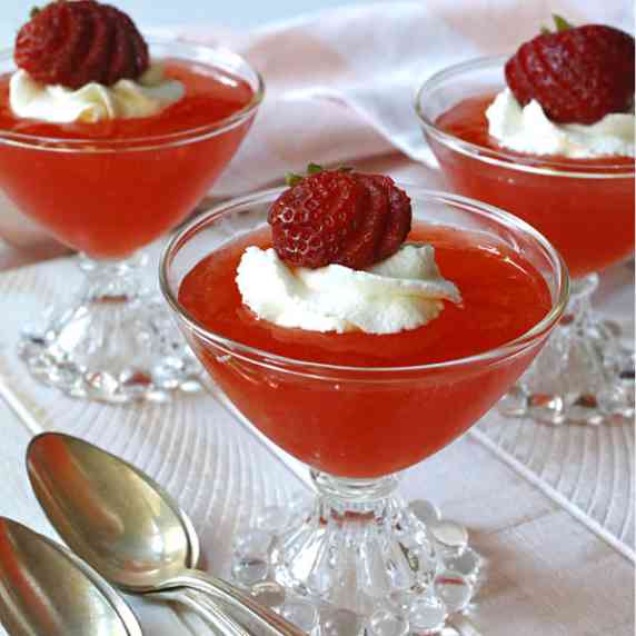 Three dessert glasses filled with strawberry gelee.