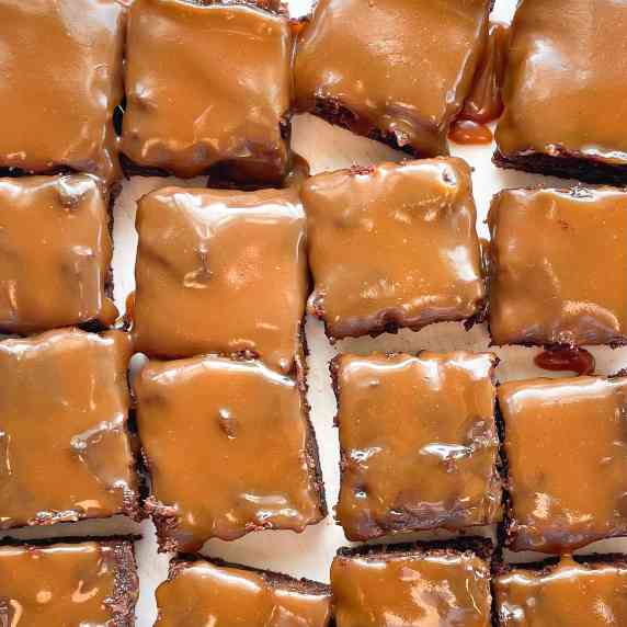 sixteen brownies topped with gooey caramel.
