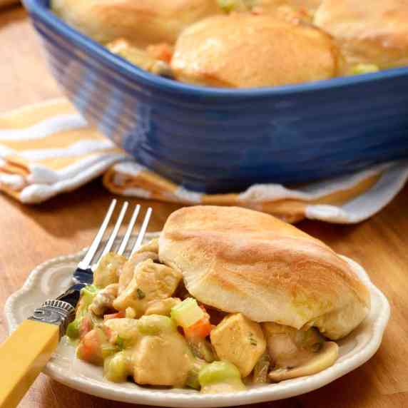 Plate holding a single serving of Chicken Pot Pie Topped with Biscuits, with pan in background