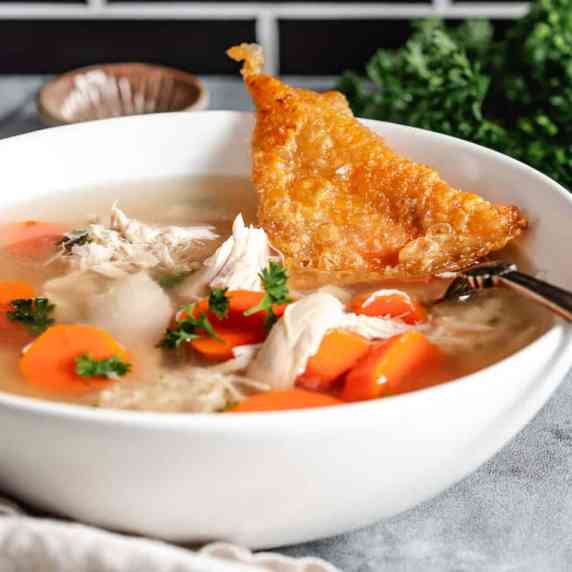 Bowl of chicken soup with carrots.