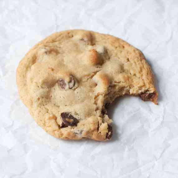 A chocolate chip cookie with a bite taken out of it. 