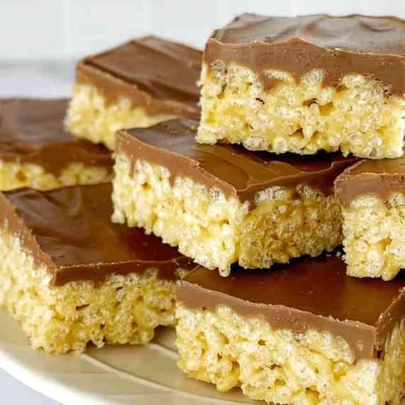 peanut butter rice krispie treats with chocolate on top on a white plate.