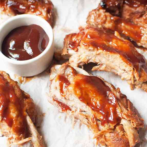 ribs next to a bowl of barbecue sauce