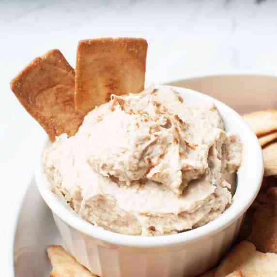 A cream cheese based dip with cinnamon sugar chips in it and then surrounded by it.