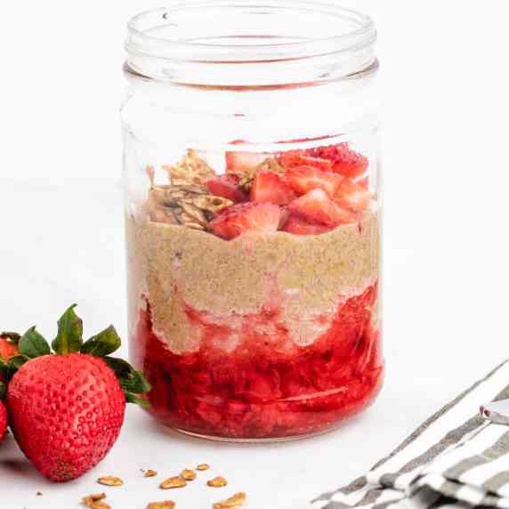 Flax seed pudding in a jar with mashed strawberries on the bottom.