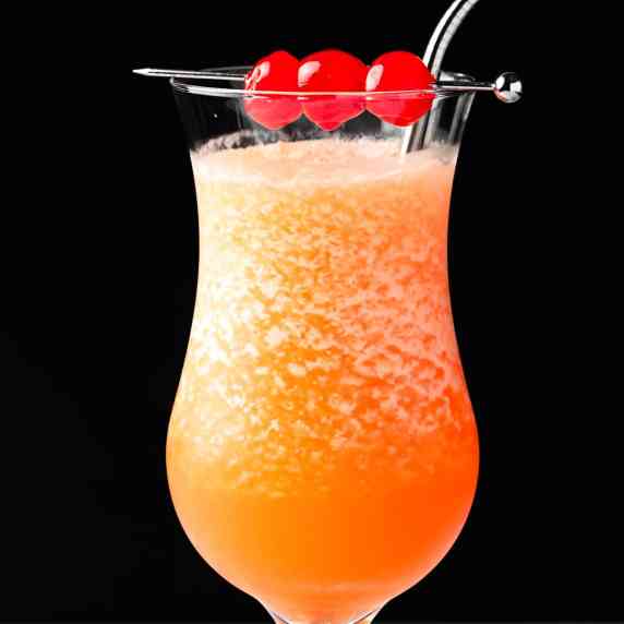 A frozen hurricane cocktail garnished with maraschino cherries.