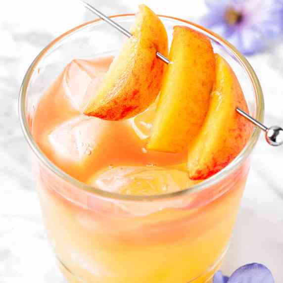 A georgia peach drink garnished with fresh peach slices.
