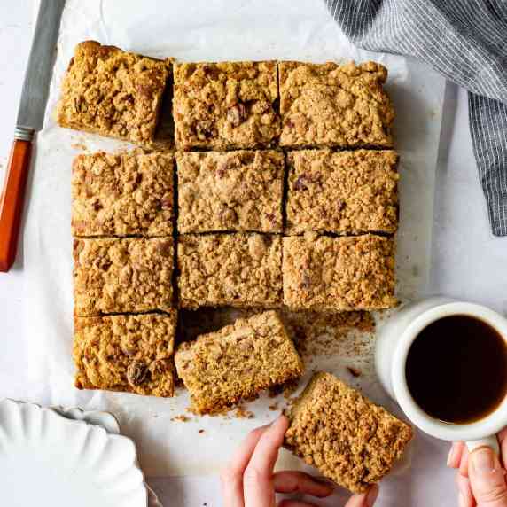Gluten-free coffee cake with a cinnamon crumb topping is slice into squares.