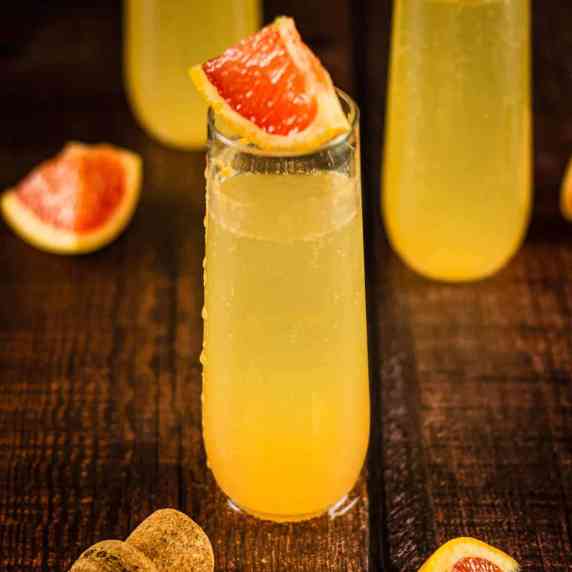 stemless champagne flute with grapefruit cocktail with a wedge of grapefruit on top