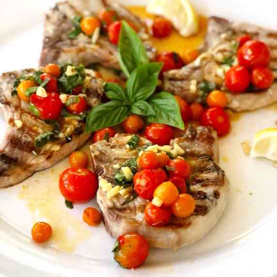 grilled pork chops with tomatoes on top