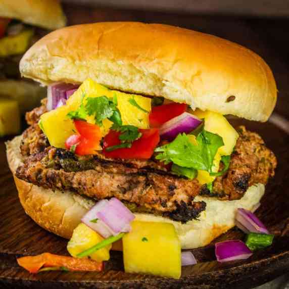 turkey burger made with hatch chiles on a bun topped with fresh pineapple salsa