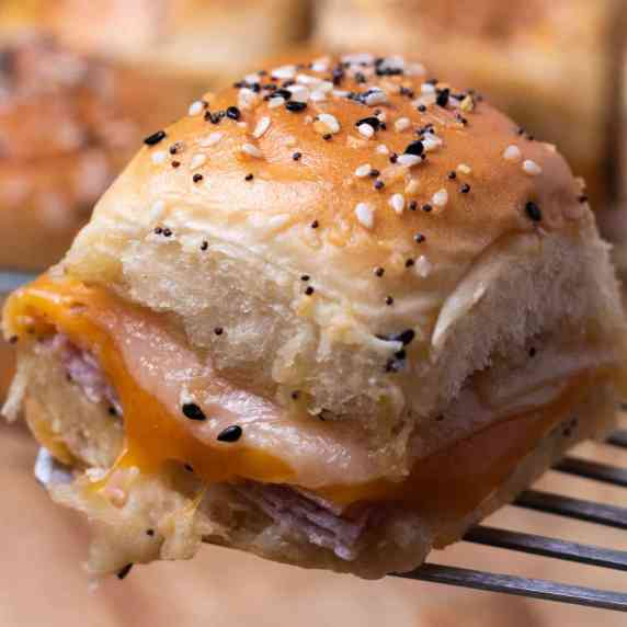 Southern style ham and cheese slider being served with a metal spatula.