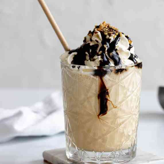 Glas with ice coffee, whipped cream, and whipped cream with a white background