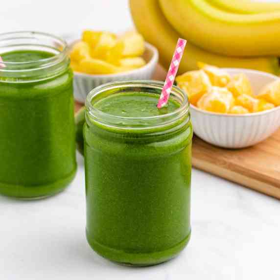 Island green smoothie in a glass jar with a straw.