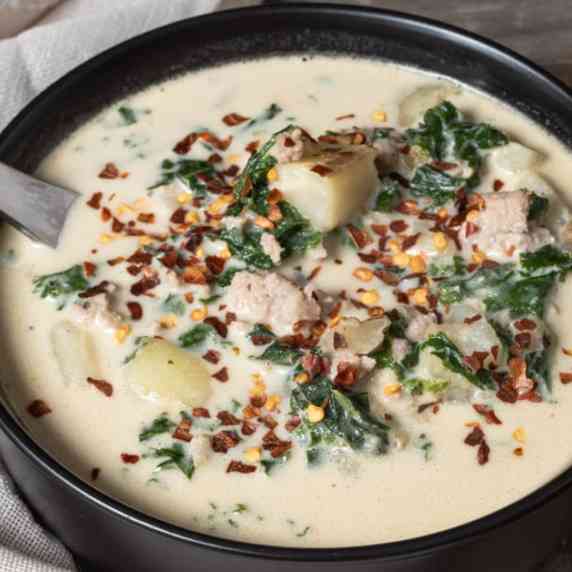 A bowl of Italian Sausage soup with creamy kale and potato.
