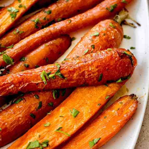 Image of maple roasted carrots on white plate.