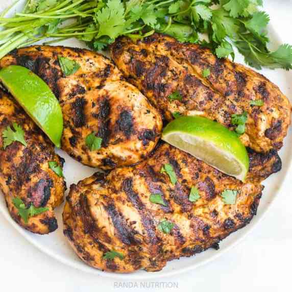 mexican grilled chicken on a plate with limes