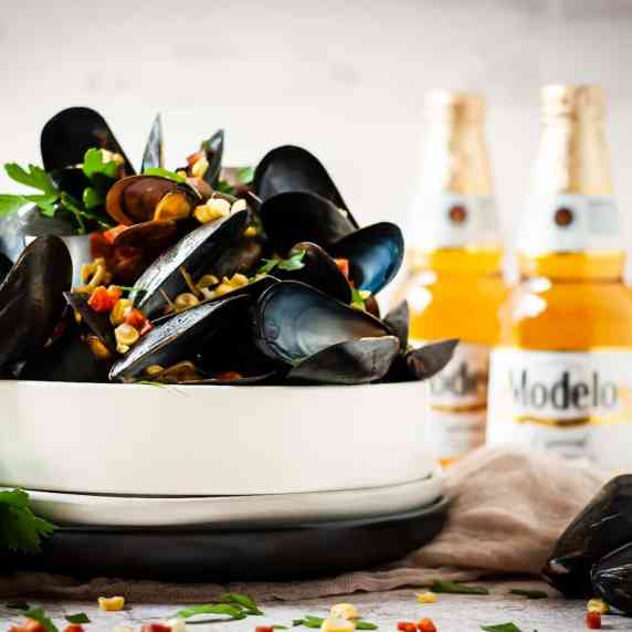 Mussels in a dish with corn and beer