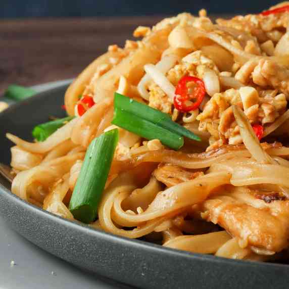 pad thai noodles and chicken on a plate