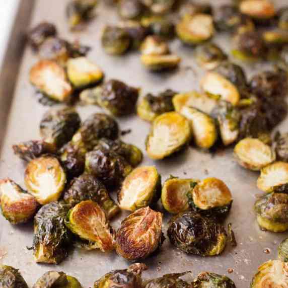 Perfectly roasted brussels sprouts halves on a baking sheet.