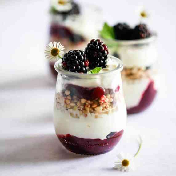 3 little jars of parfait.Layers of blackberry jam, buckwheat & yogurt, topped with blackberries.