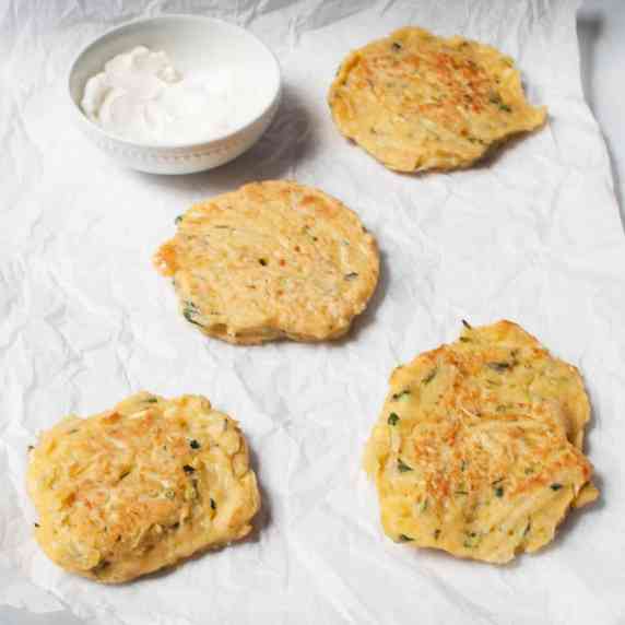 sourdough discard zucchini fritters with a bowl of sour cream dipping sauce.