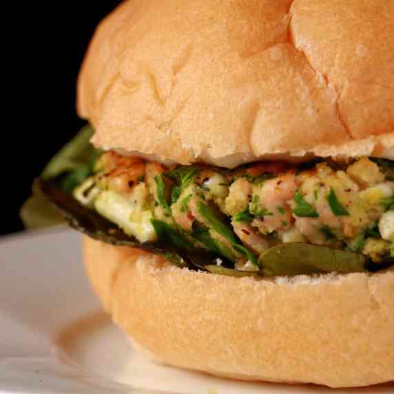 A salmon burger with flecks of spinacha and feta throughout.