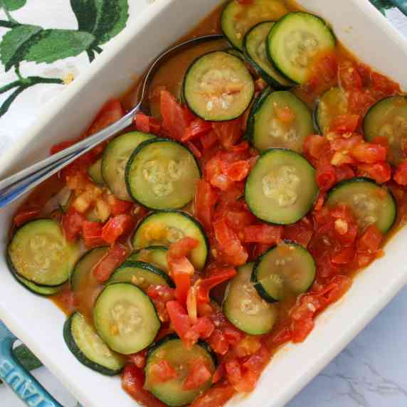 A serving dish of summer squash and tomatoes