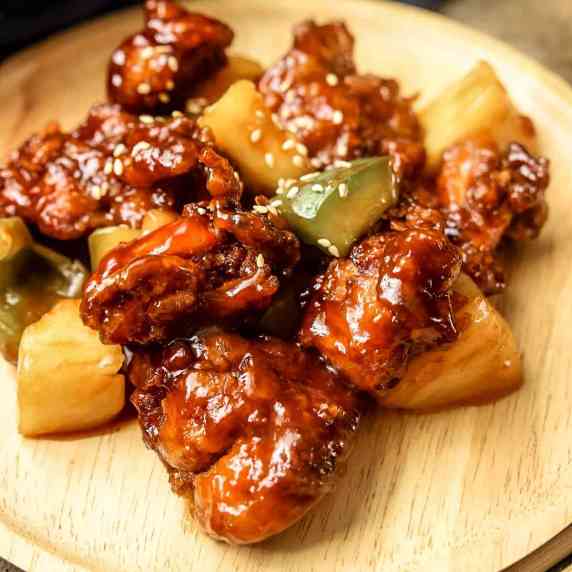 Sweet and sour chicken on a wooden plate