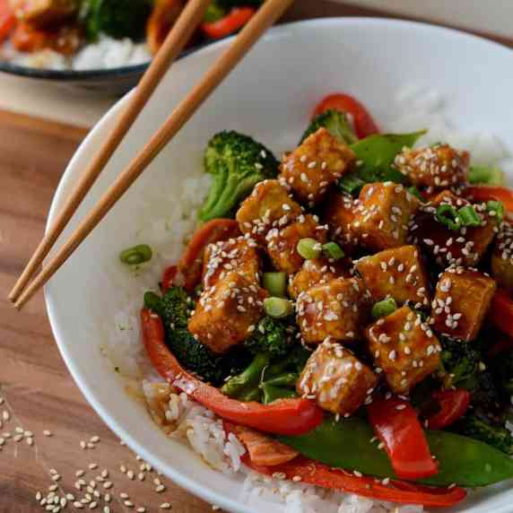 This is a photo of crispy teriyaki marinated tofu with sesame seeds and red peppers. 
