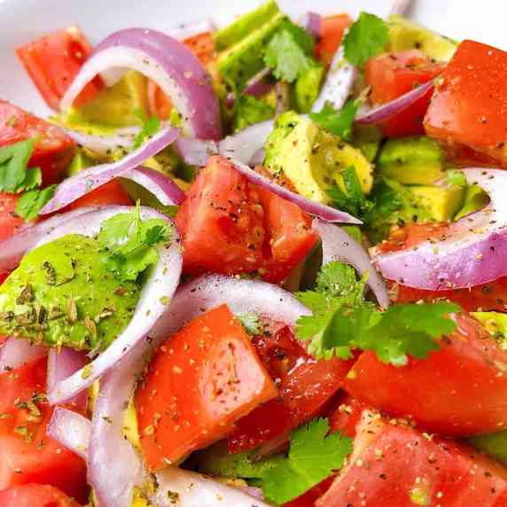 Close up of tomato and avocado side salad.