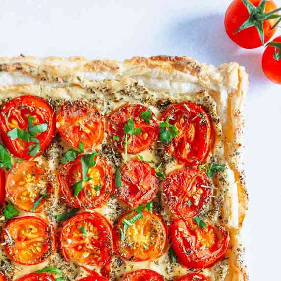 tomato tart and cherry tomatoes on a white countertop