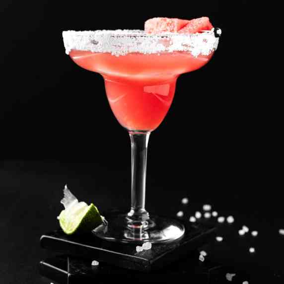 A watermelon on the rocks margarita on a black background.