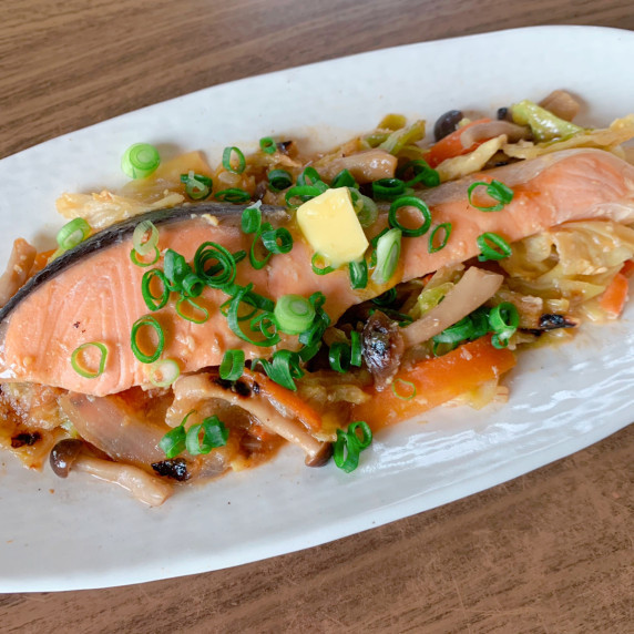 A dish of steamed salmon and vegetables seasoned with miso. 