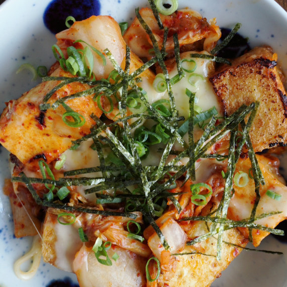 The thick deep fried tofu is topped with kimchi and cheese.