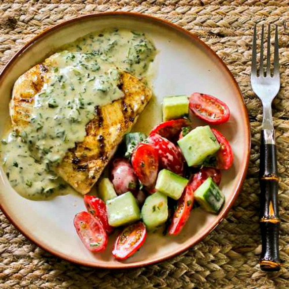 grilled halibut with basil vinaigrette shown on serving plate with tomato-cucumber salad