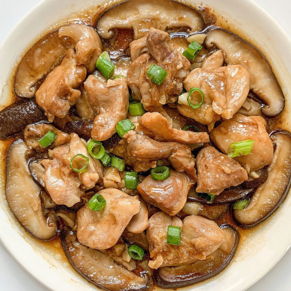Finished stewed chicken with mushrooms on a white plate