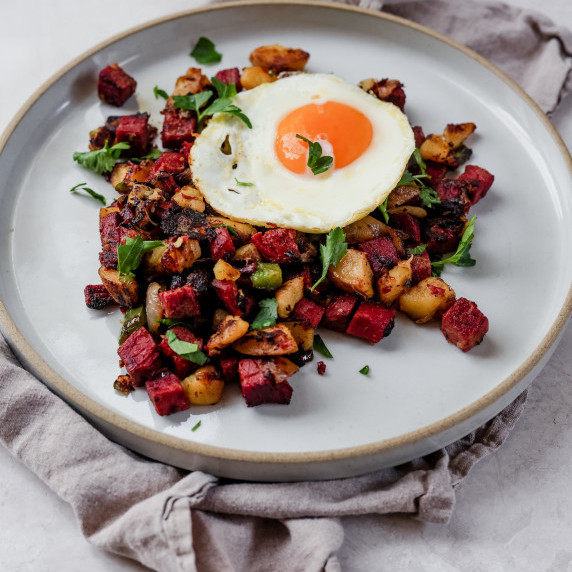 corned beef hash with over easy egg on white plate 