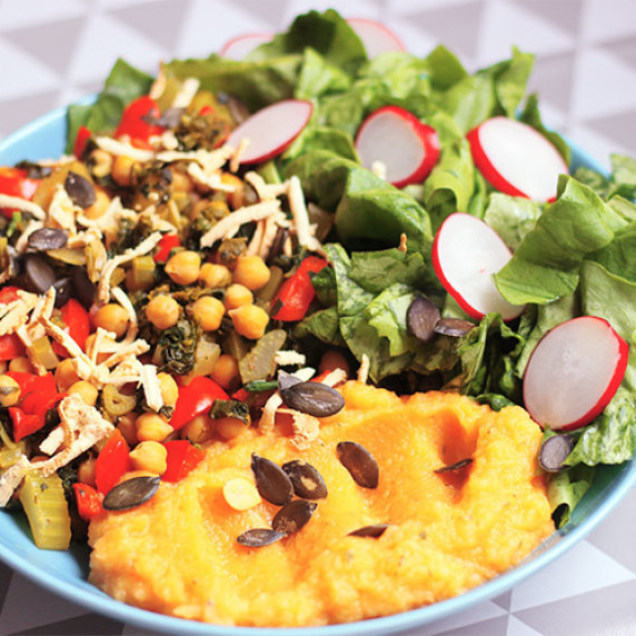 A bowl of veggie stir fry with chickpeas, smoked tofu and mashed puree with a side of a fresh salad.