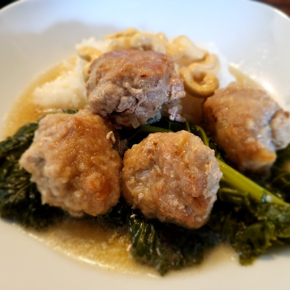 Chinese pork meatballs sat on a bed of super healthy kale in pork stock