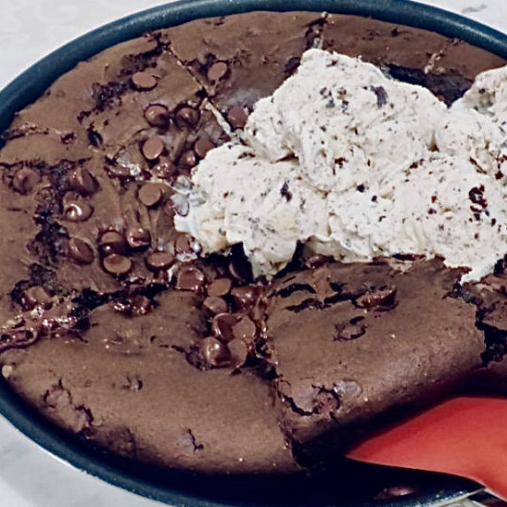 Triple brownie skillet with a red spoon on a white table. 