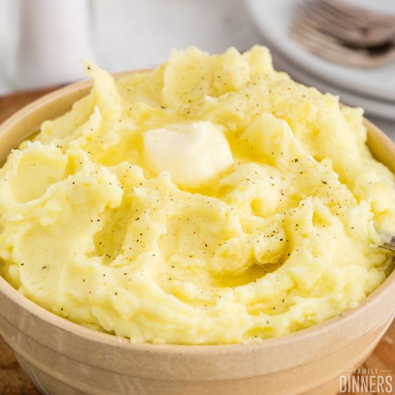 Bowl of mashed potatoes with butter on top.