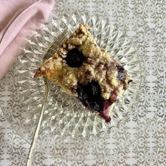 A white coffee cake with blueberries and cinnamon