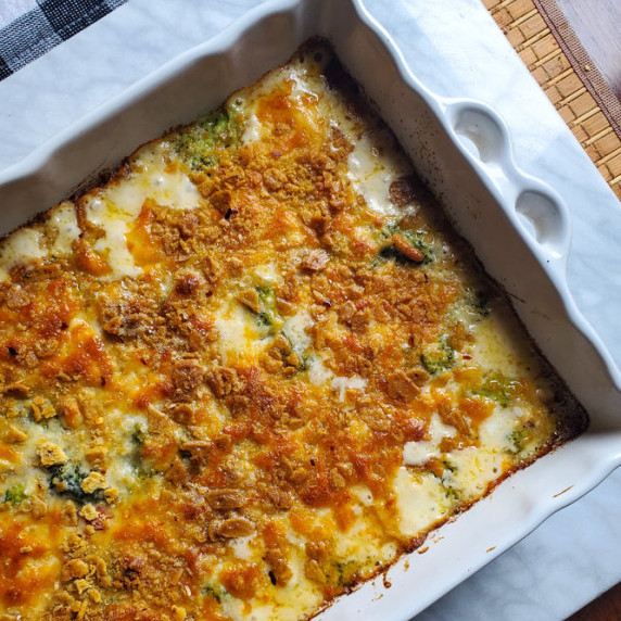 A creamy casserole with a golden brown topping in a white baking dish.