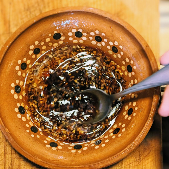 stir fry sauce being stirred in a clay bowl